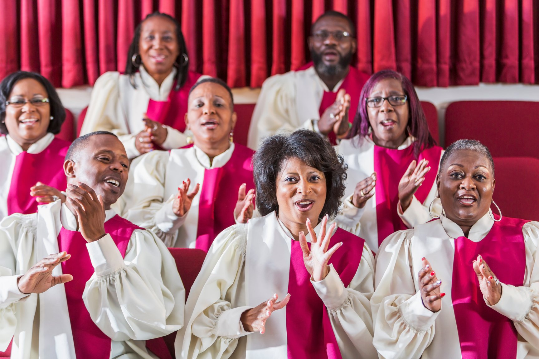 Mature black women and men singing in church choir